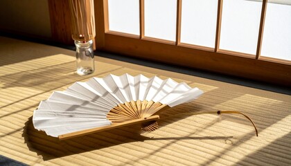 畳に広げられた和紙の扇子と透き通るガラス風鈴、窓辺の自然光が織りなす繊細な影が和の空間に優しい風を呼び込む


