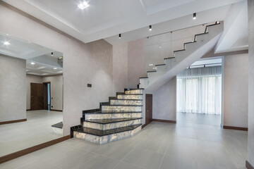A stylish entrance group with a beautifully decorated staircase made of modern materials and a...