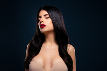 Luxurious brunette woman with red lipstick against dark blue background, showcasing beauty and...