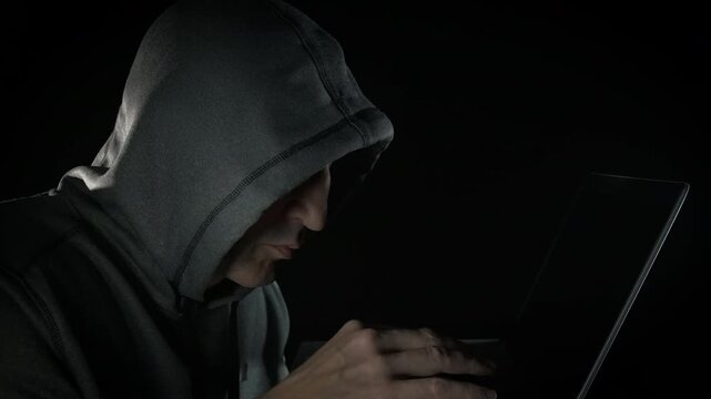 Steal data on computer with police. A view of man hacker with notebook is caught by police during cyber crime indoor