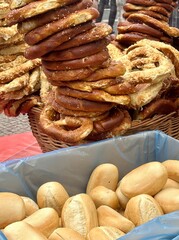 Fresh buns and traditional pretzels are displayed outdoors 
