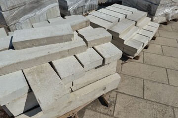 Stacks of grey concrete blocks sit on a pallet outdoors.
Concept of Building supply.