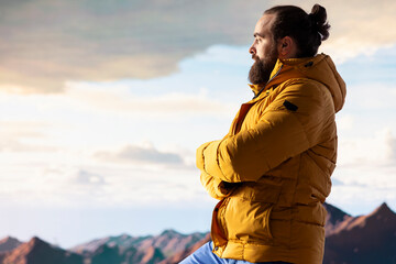 Determined climber pauses to admire the scenic view with mountains and a vast sky create a...