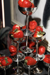  Fresh strawberries arranged beautifully in silver goblets create an elegant display. The vibrant red of the berries contrasts with the metallic shine, offering a luxurious touch to the setup.