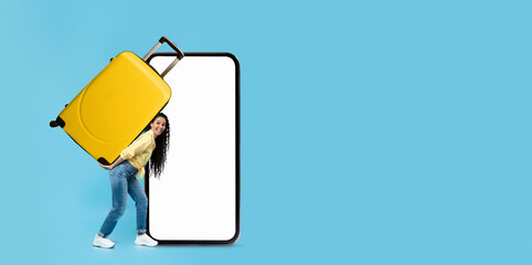 A tourist joyfully holds a yellow suitcase while standing next to a blank smartphone screen, ready...