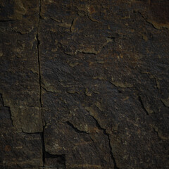 A textured stone background with a brutal, monolithic rock formation, cracks, and fragments. Perfect for design templates or banners, showcasing raw power and natural beauty.