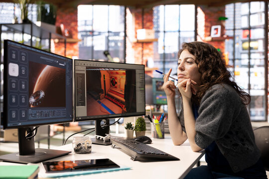 Woman works with AI generated app to develop a futuristic spaceship station. Neural network powered software uses automation and machine learning to generate realistic game environments.