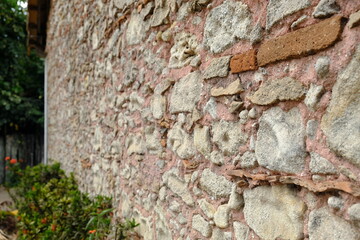 Parede antiga de pedra com textura rústica e tijolos aparentes
Old stone wall with rustic texture and exposed bricks