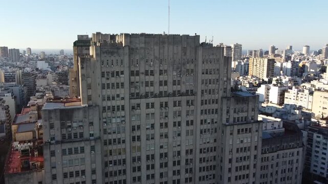 Drone approaches the rooftop of the School of Medicine, revealing architectural details of the building and the Buenos Aires skyline.