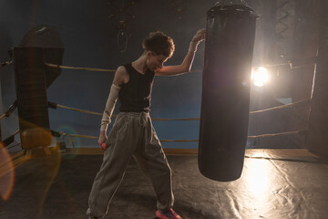 Boxing with a punching bag, sports achievements concept, female wrestler in a boxing ring, cinematic image, mood, motivating stories