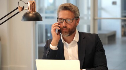 Remote working. Phone call communication. Businessman busy working on office laptop. Worried man has business phone call. Successful businessman freelancing online. Business man working online - Powered by Adobe