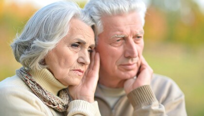 Elderly couple in pensive pose outdoors