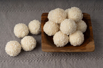 Coconut candies pile, coco ball. White truffle ball, indian ladoo or laddu with sweet cream and coco
