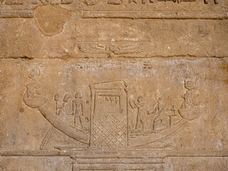 Jeroglíficos egipcios tallados en piedra con figuras de animales y símbolos sagrados