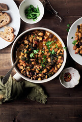 Stewed Borlotti beans with Cavolo Nero kale, tomatoes, Shiitake mushrooms with lots herbs and seasoned with chili pepper flake and served with sourdough bread slice. Healthy comfort meal concept.