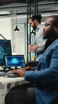 Vertical Video Black man IT expert handles neural networks systems for data forecasting, combining AI automation tools with digitalization to drive multinational company efficiency and innovation