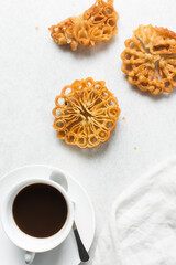 Overhead view of sassafa northern nigerian snack, top view of rosette cookies on a white marble countertop
