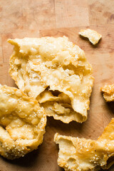 Overhead view of dublan northern nigerian snack, top view of dublan on a wood countertop, flaky fried dough coated in syrup and sesame