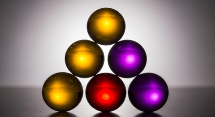 Six illuminated translucent glass spheres arranged in triangular pyramid formation with yellow amber and purple magenta colored lighting effects on gradient background