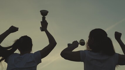 silhouette of a girl with cup in hand rejoice in victory, jump up with happiness, achieve success...