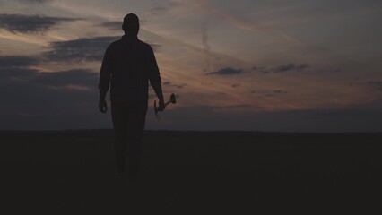 silhouette of farmer with shovel field, agriculture, gardening business spring work, summer sunset...