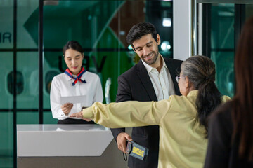 Airline ground staff using metal scanner for security check every passenger in the airport departure terminal for safety protocol before boarding into plane