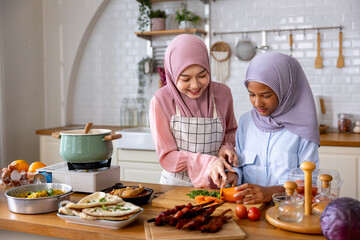 Family of happy Arab muslim mother is teaching her daughter cooking and food preparation in the kitchen for tasty halal meal at home in Middle east and Persian cuisine culture usage