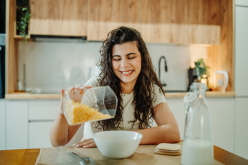 Young caucasian woman eating cereals for breakfast at home	