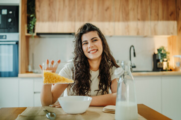 Young caucasian woman eating cereals for breakfast at home	