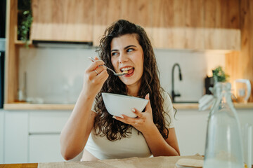 Young caucasian woman eating cereals for breakfast at home	