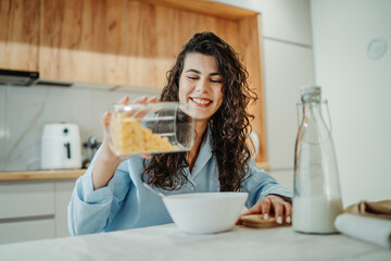 Young caucasian woman eating cereals for breakfast at home	