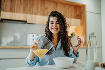 Young caucasian woman eating cereals for breakfast at home	