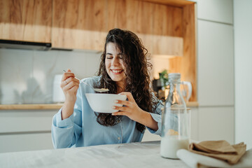 Young caucasian woman eating cereals for breakfast at home	