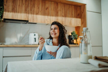 Young caucasian woman eating cereals for breakfast at home	
