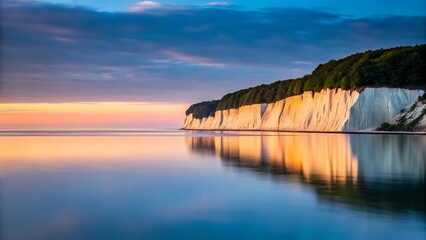 Majestic white cliffs reflecting golden sunset hues on calm ocean waters