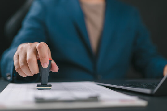 Businessman validates and manages business documents and agreements, signing a business contract approval of contract documents confirmation or warranty certificate, approval stamp