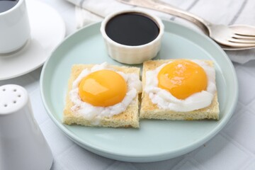 Tasty kaya toasts with half-boiled eggs served on white tiled table, closeup. Traditional asian breakfast