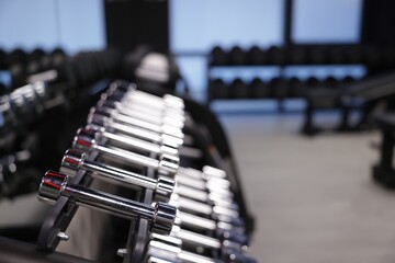 Many metal dumbbells in gym, closeup. Space for text