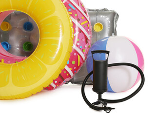 Inflatable rings, mattress, ball and manual air pump isolated on white
