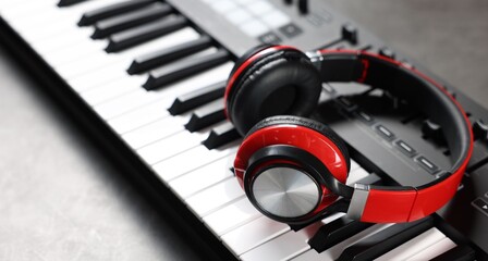 MIDI keyboard and headphones on grey table, closeup