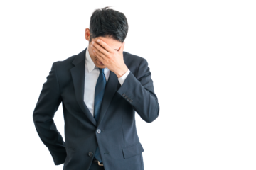 ショック・ストレスで頭を抱えるスーツ姿のアジア人中年ビジネスマン（困る・落ち込む・疲労・リストラ）
