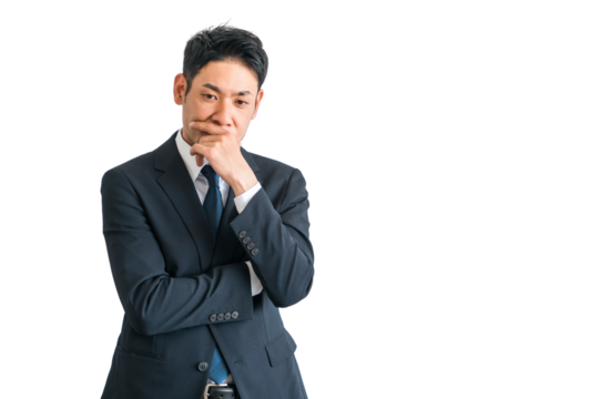 腕組みして考えるスーツ姿のアジア人中年ビジネスマン（悩む・困る・悩み・策士・戦略・作戦・検討）
