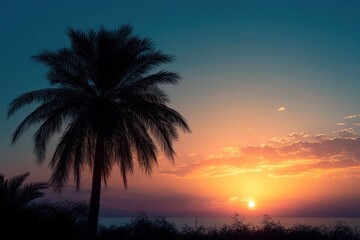 Serene sunset over the ocean with silhouetted palm tree and coastal vegetation under a colorful sky with soft clouds