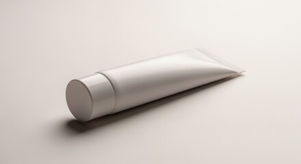 A pristine white tube of lotion or cream rests gently on a smooth, light gray , ready for use or display.