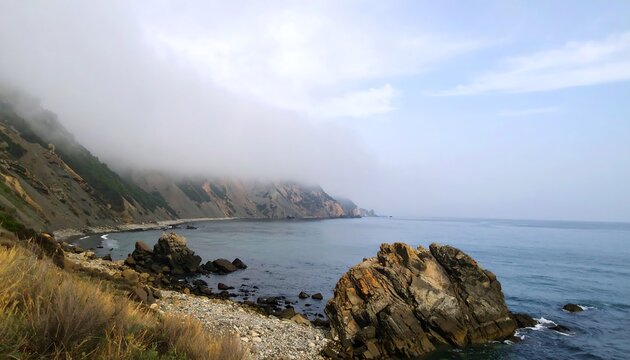 Coastal fog rolling over rocky cliffs - Powered by Adobe
