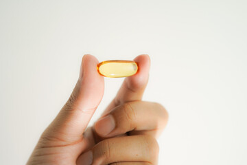 Male hand holding Oil filled capsules, softgel of food supplements, fish oil, omega 3, vitamin E