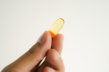 Male hand holding Oil filled capsules, softgel of food supplements, fish oil, omega 3, vitamin E