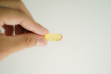 Male hand holding Oil filled capsules, softgel of food supplements, fish oil, omega 3, vitamin E
