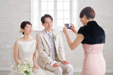友達とスマホで写真を撮る新郎新婦