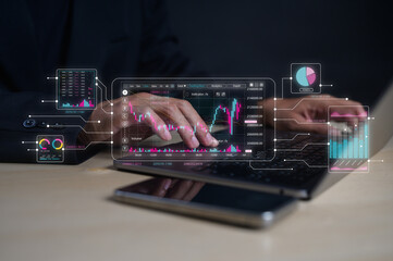 A person uses a laptop with overlaid digital charts and graphs representing financial data and analytics.